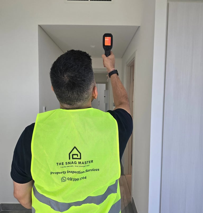 Engineer using thermal camera during ceiling inspection in Abu Dhabi villa