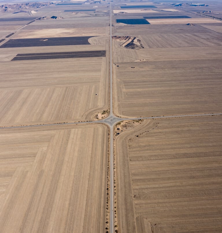 Aerial photography of a vast rural plot in Northeast Nevada. The shot captures the strategic layout of the land including natural drainage and access roads in professional sand beige tones.