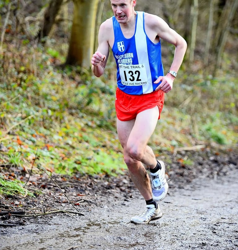 a man running on a trail in the woods