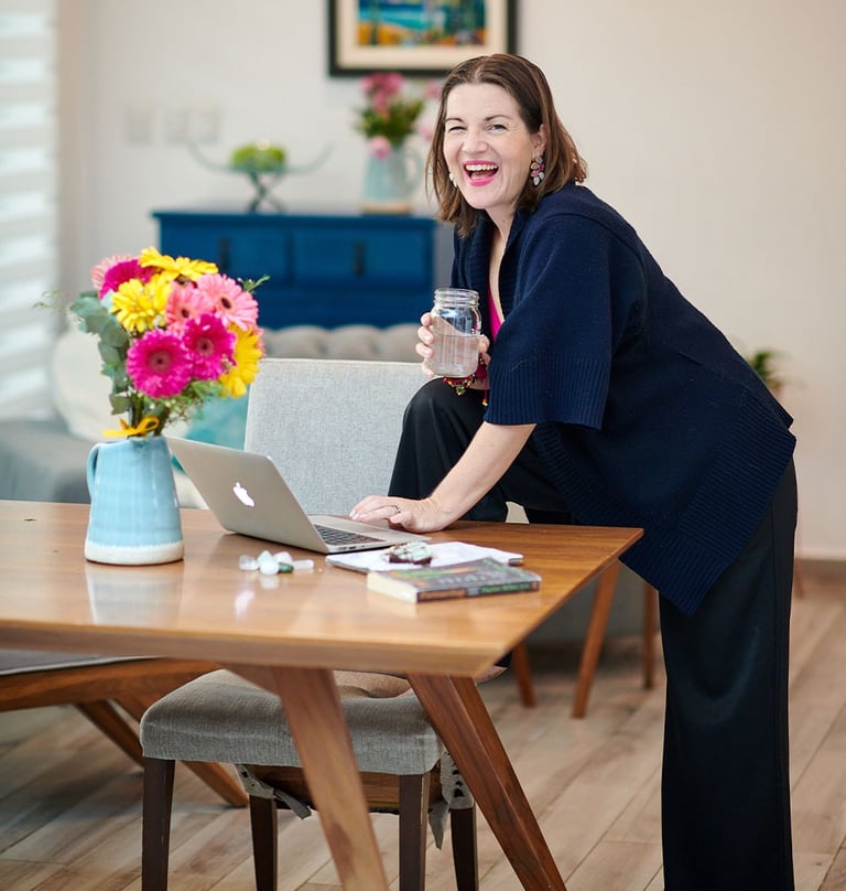 megan swan wellness coach for women standing at table with water