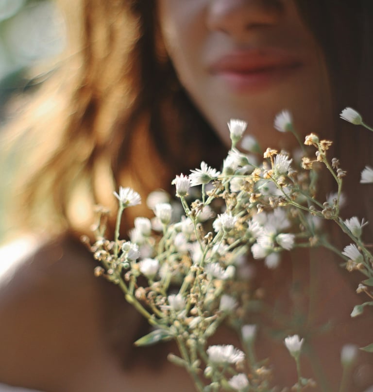 femme avec une robe blanche tenant un bouquet de fleurs