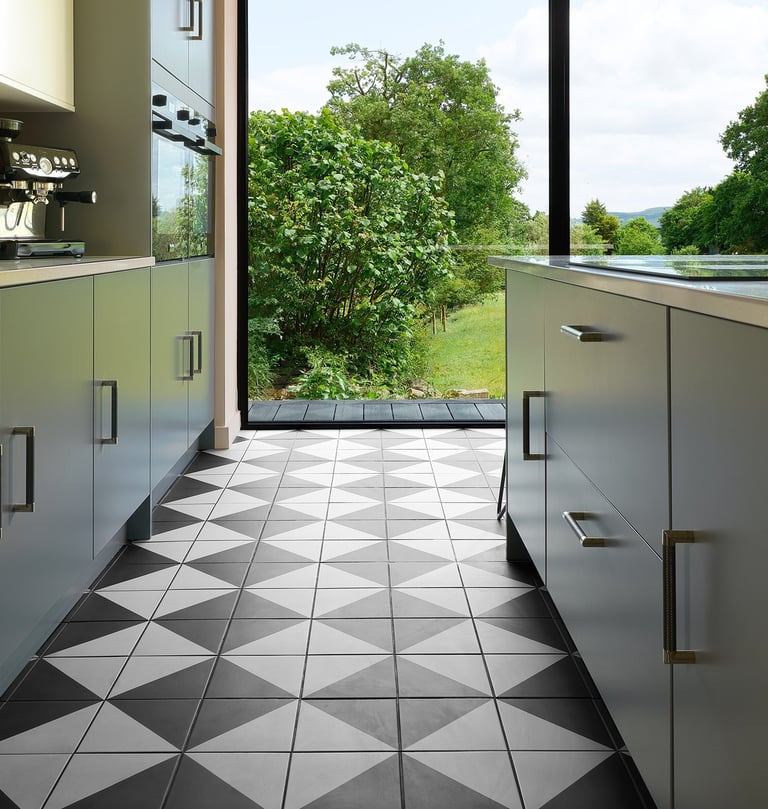 Black and white floor tiles laid in a diamond pattern with oak wood flooring