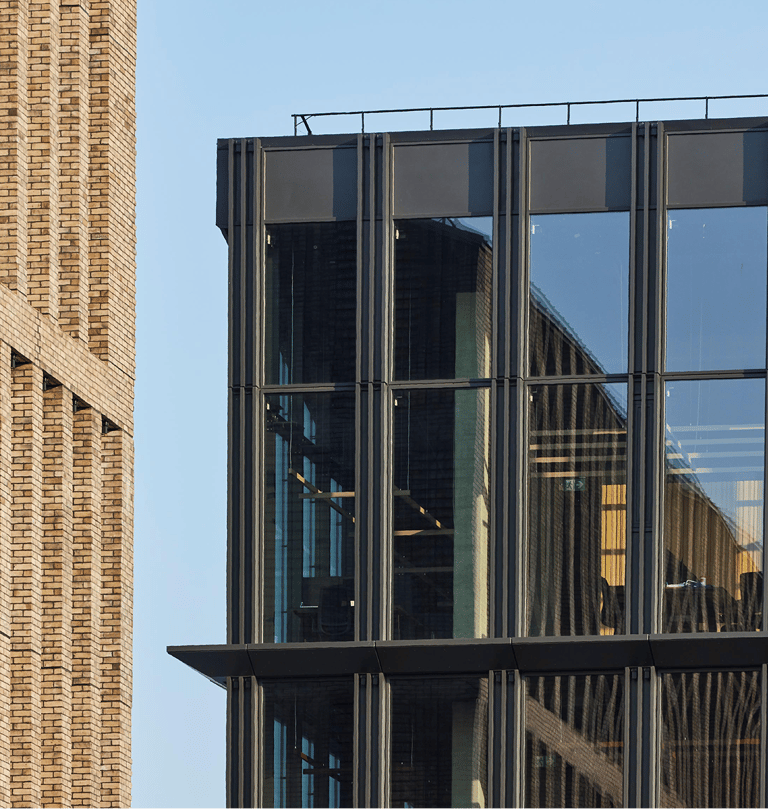 Modern office building facade featuring textured brown brick and glass windows.