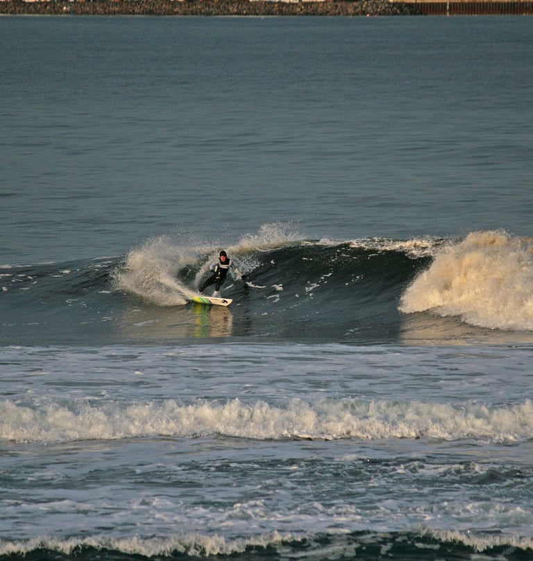 A surfer doing a forehand cutback in the early morning sun.