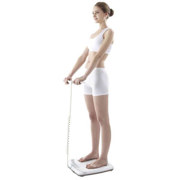 Woman standing on an impedancemeter and holding the electrodes with her hands