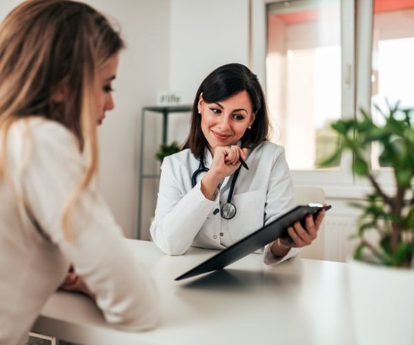 a female doctor in a white coat and a stethoscoped steth