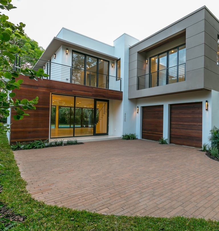a brick driveway to a square looking custom designed luxury home