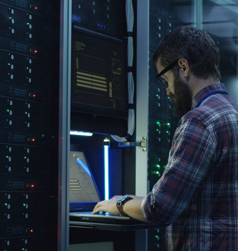 a man in a plaid shirt is standing in front of a server rack