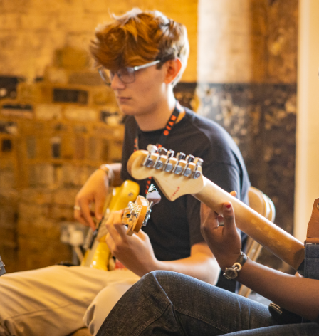 An image of Jamie Walker playing electric bass with NYJO