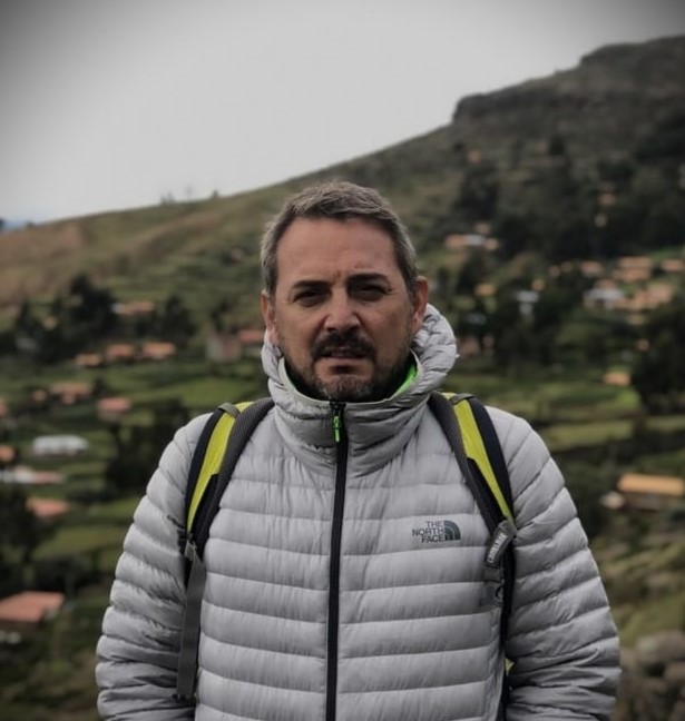 a man in a grey jacket and a backpacker