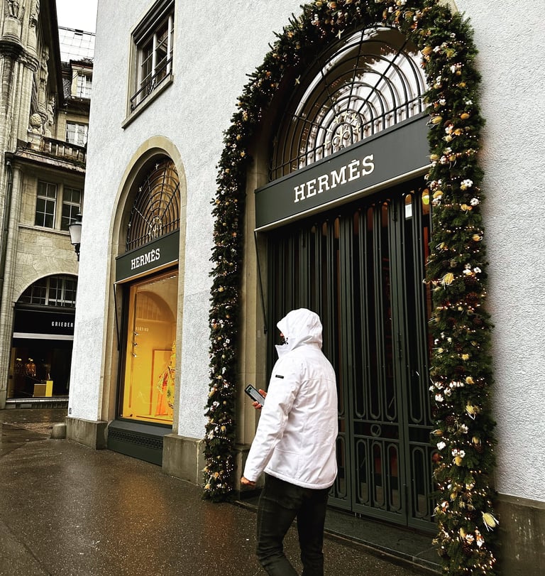 Male model in white coat walks along the Hermes store in Munich, Germany @LVF.LVX