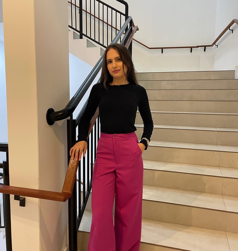 Mulher usando uma calça pantalona  rosa e blusa preta