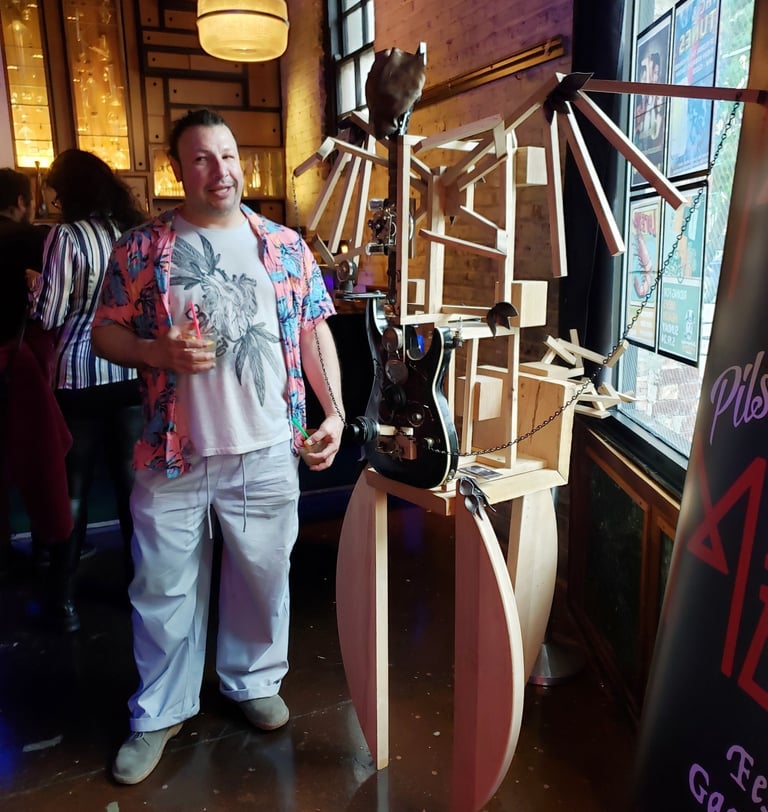 Frank con esculktura de reciclado de madera y guitarra