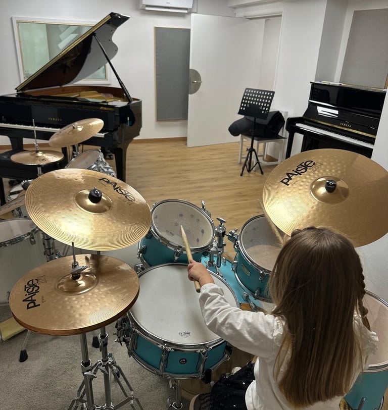a young girl playing drums in a music school