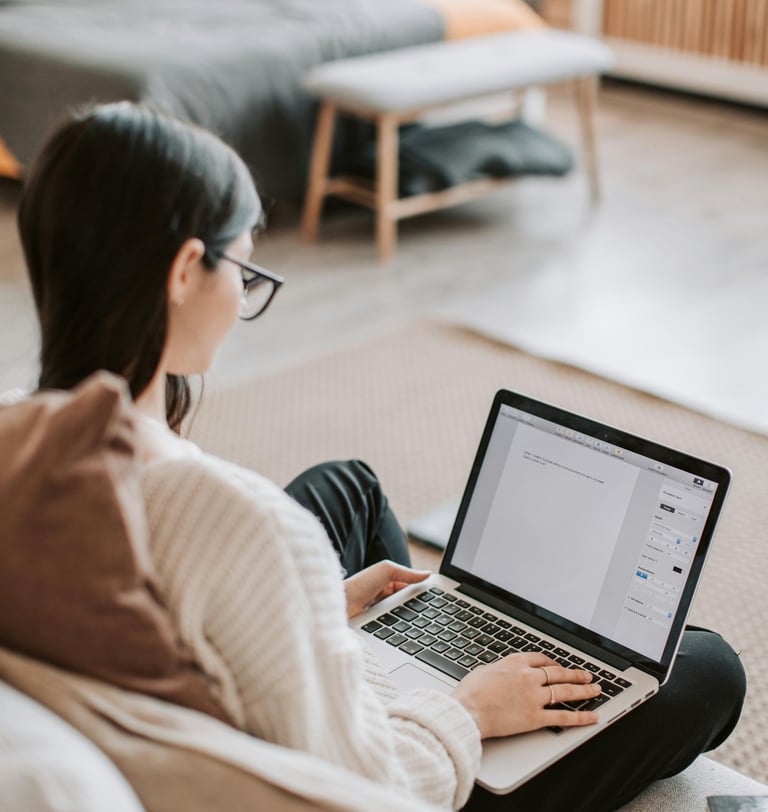 a woman sitting on a couch with a laptop