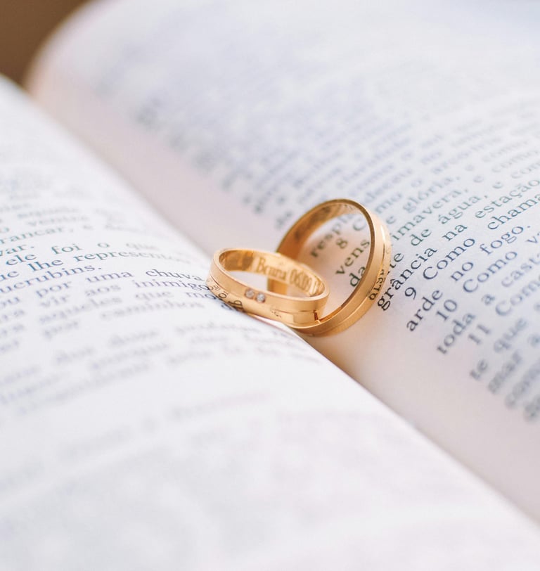 a wedding ring with two wedding rings on top of a book