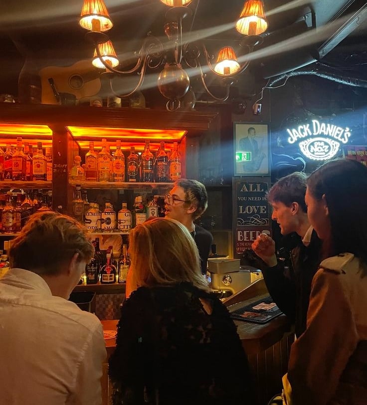 a group of people standing around a bar in Riga