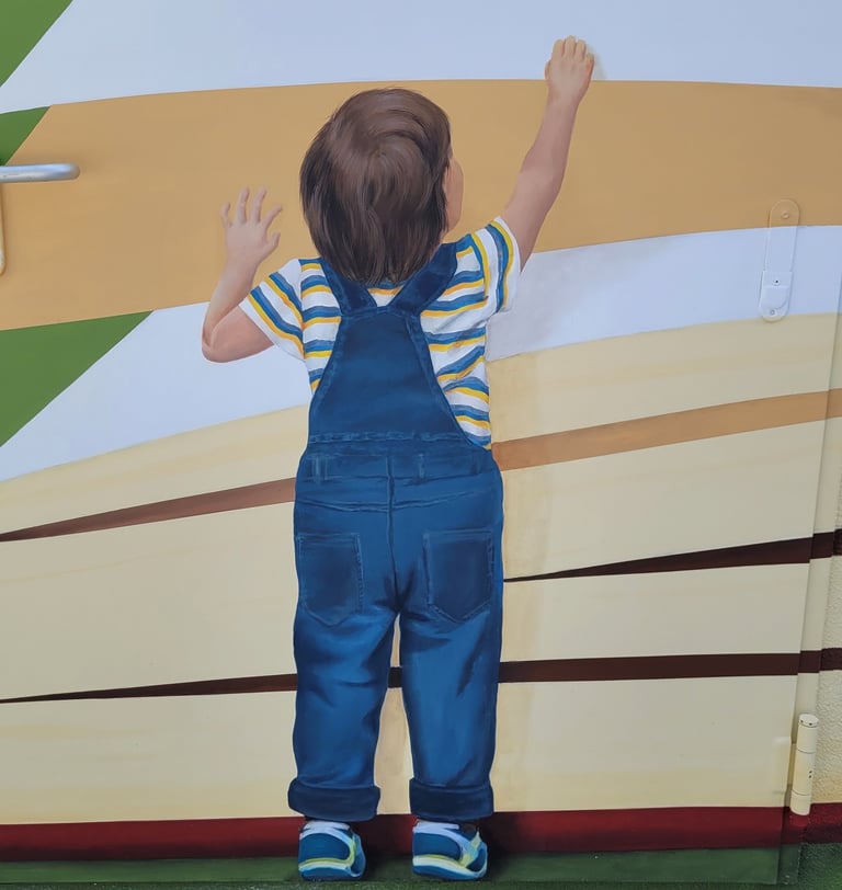 Détail d'une fresque murale: un garçon debout de dos se hisse sur la pointe de pieds. Viry, Jura.
