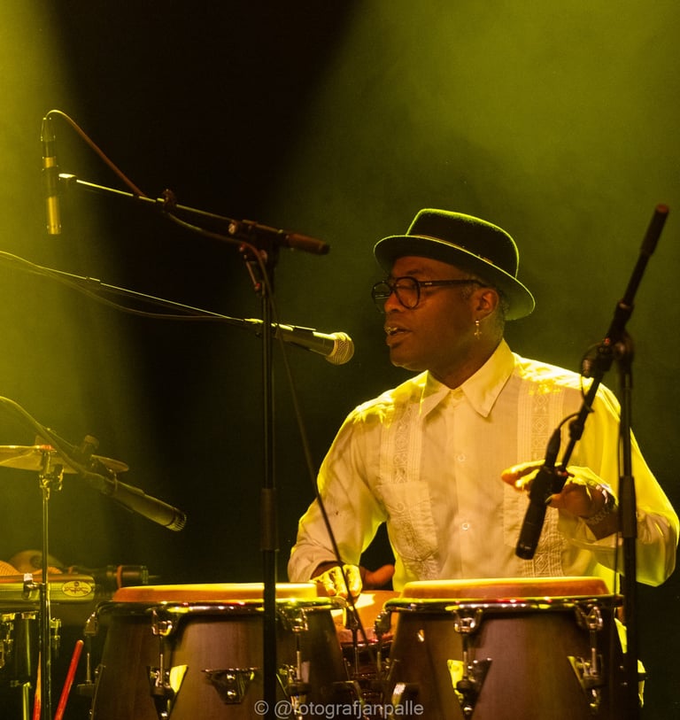 a man in a hat playing percussion congas