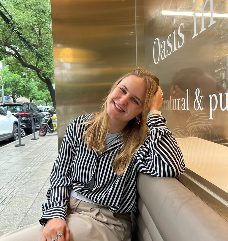 artist carina exner sitting on a bench smiling