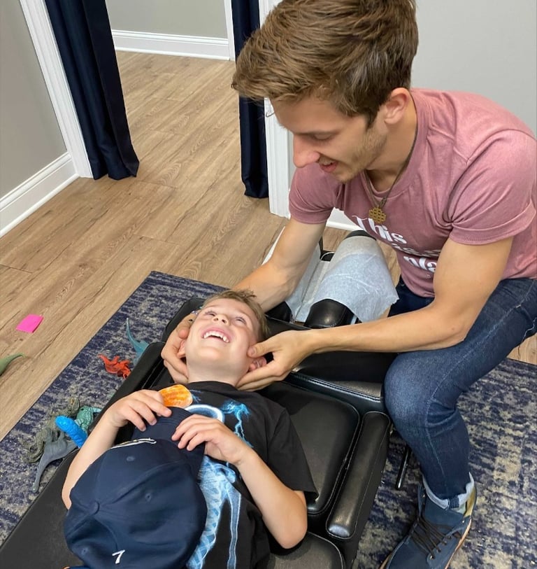 Pediatric chiropractor performing gentle adjustment on a child with autism in Franklin, TN