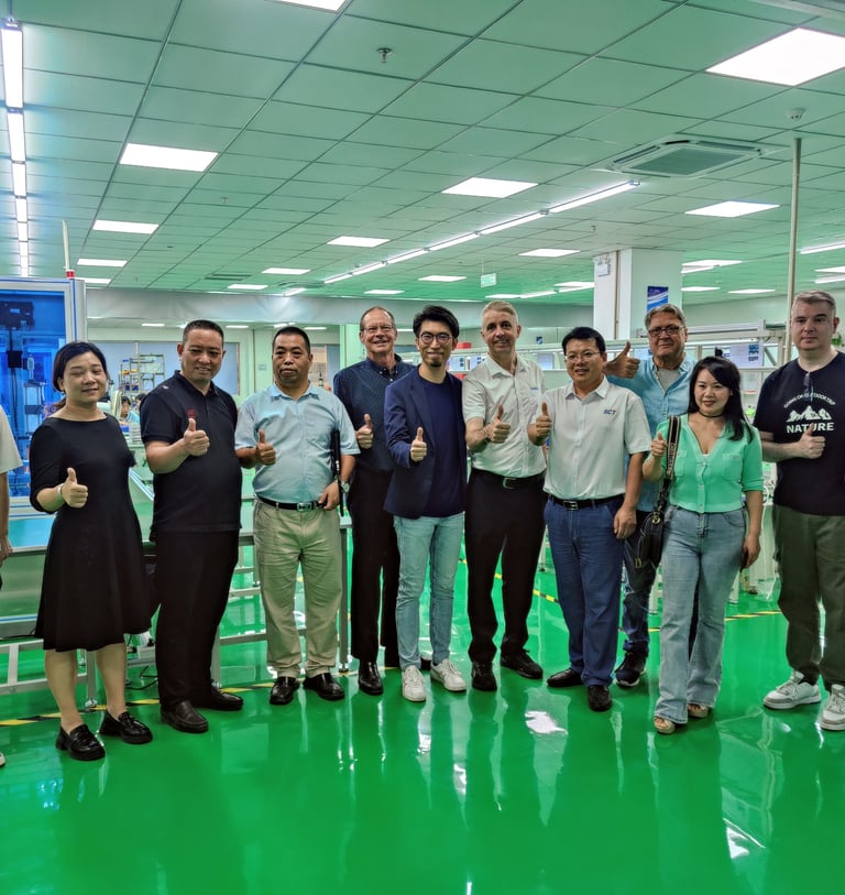a group of people standing in a factory with thumbs up