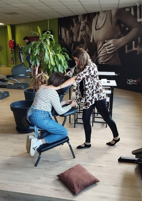 Un massage assis sur une personne détendue, installée sur une chaise ergonomiqu