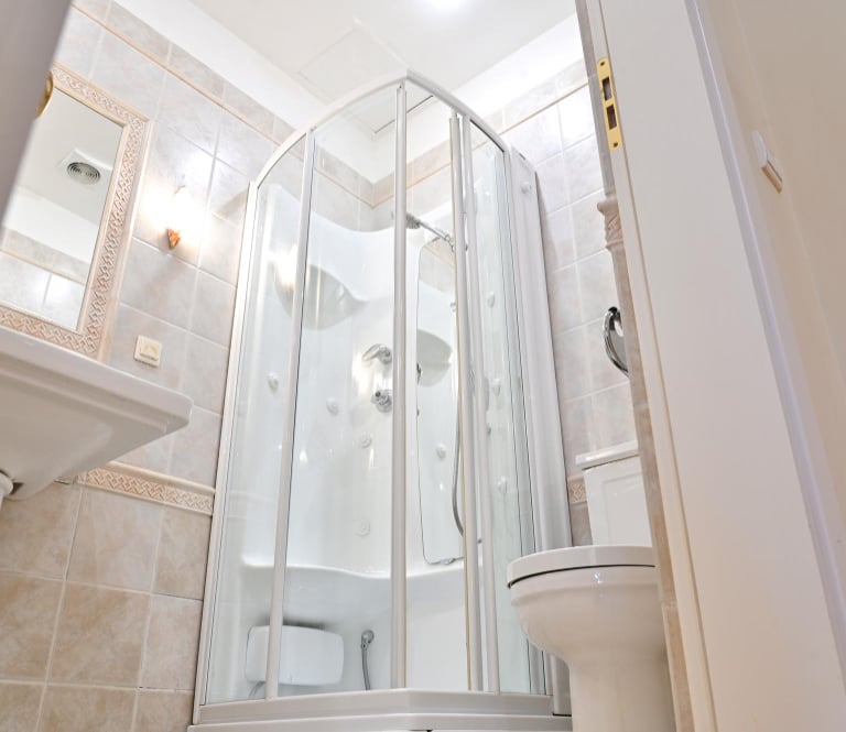 White hydromassage shower cabin with built-in seat and body jets