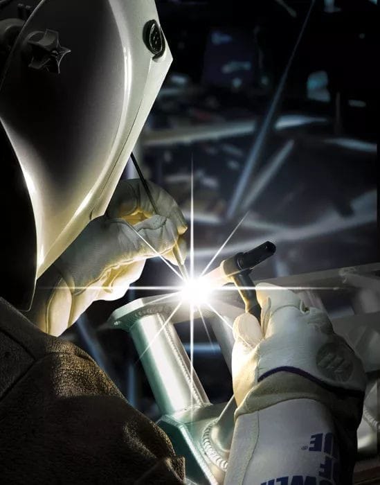 a person welding a piece of metal with a light shining on the side