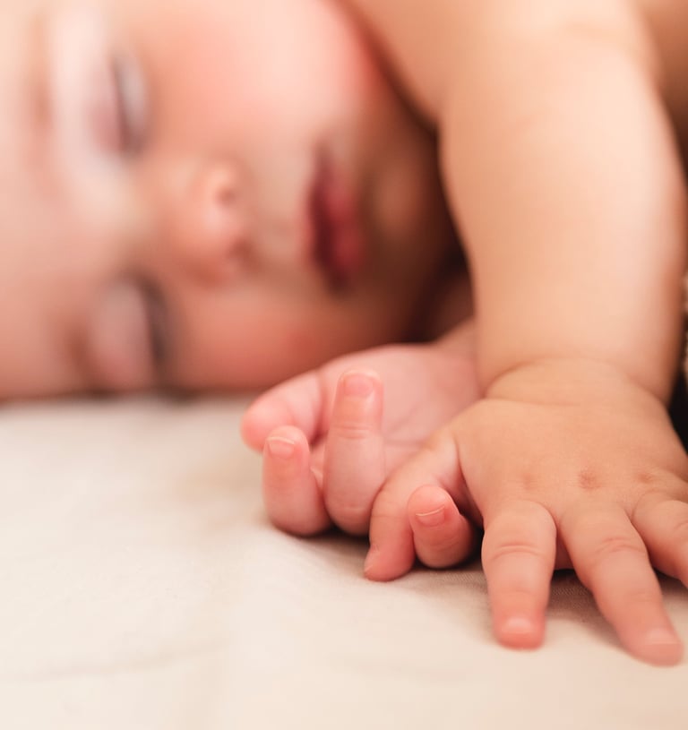 a baby is laying on a bed with a blanket