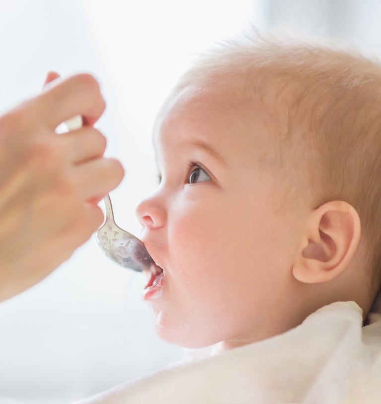a baby gets food from a spoon
