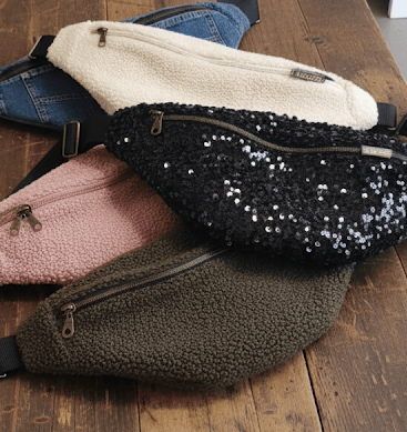 plusieurs sacs bananes lilyboo faites main de diferentes couleurs posés sur une table