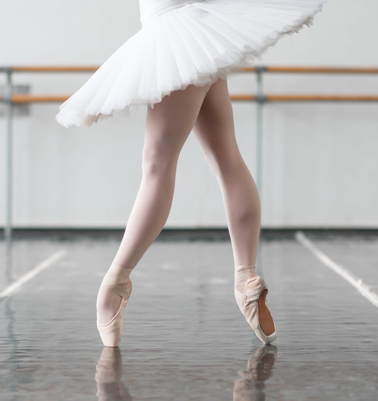 a ballerina in a white dress and a ballet shoe