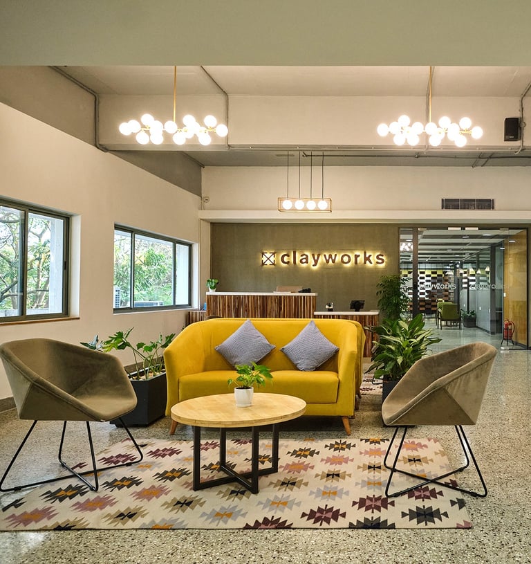 a large lobby area with a yellow couch and chairs- Clayworks create