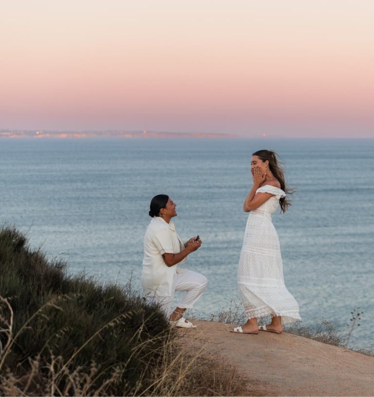 a man proposing a woman on a cliff overlooking the ocean
