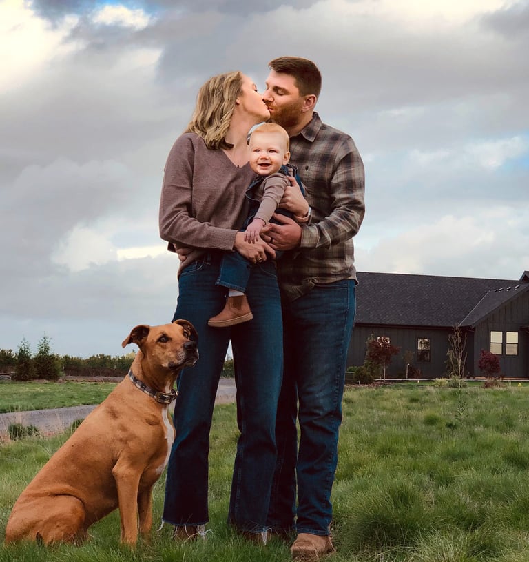 a family and dog standing in front of a house
