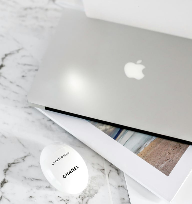 Luxury workspace flat lay with laptop and Chanel cream