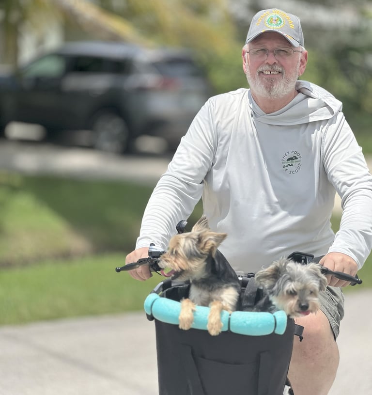a man riding a bicycle with two dogs in a basket