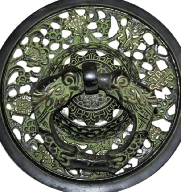 a decorative metal plate with a green dragonfly