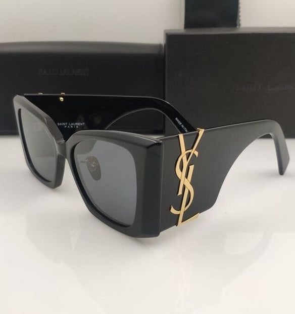 a pair of YSL sunglasses with a black frame and a black box
