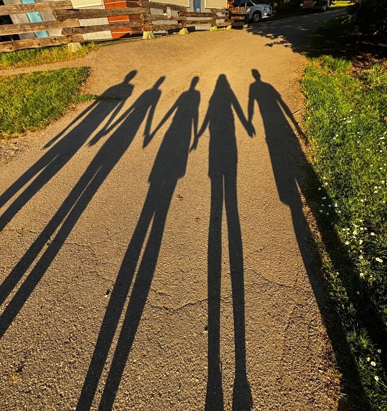 Familia tomada de la mano frente a su hogar, símbolo de herencias y sucesiones