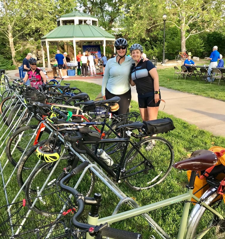 Two women posed in front of a large row of parked bikes