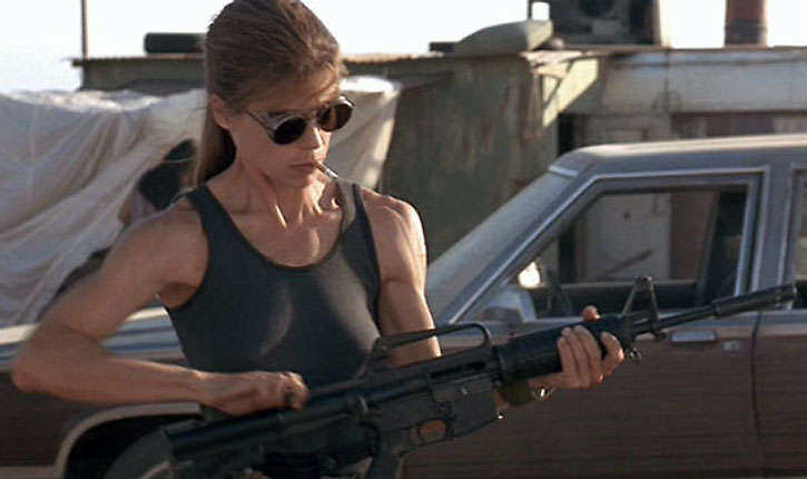 a woman in a tank top holding a gun