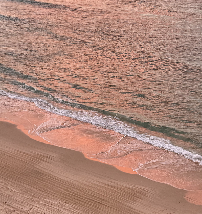 un atardecer rosado reflejado sobre el agua del mar
