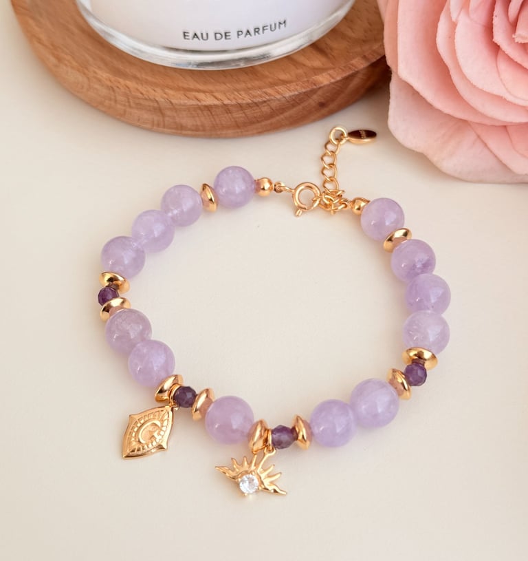 ein Armband mit Rosenquarz und vergoldeten Anhängern