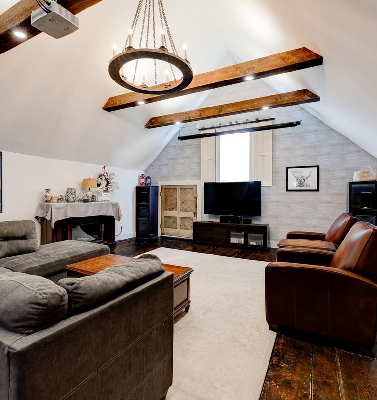 family media room with vaulted ceiling and beams