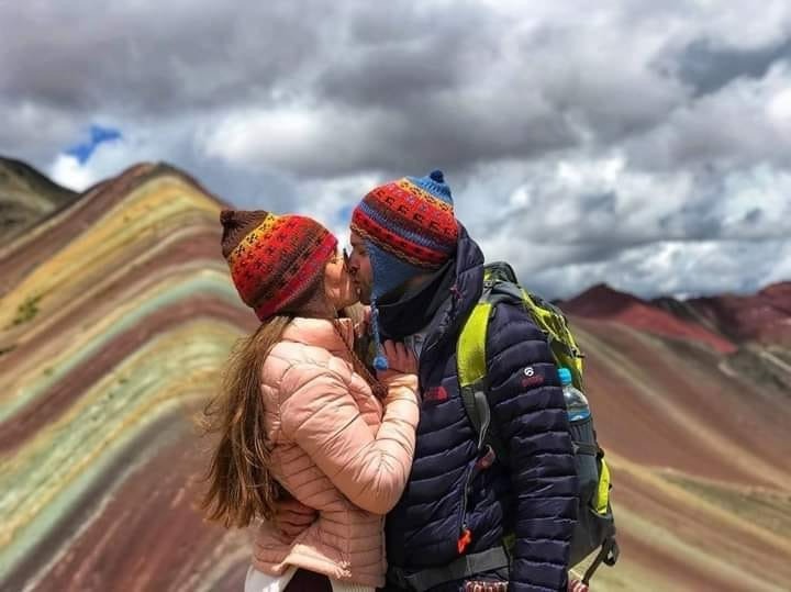 pareja felices en montaña de colores vinicunca
