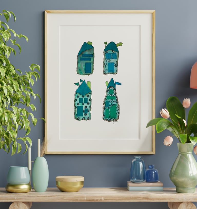 a picture of four whimiscal houses and a vase with flowers along with vases on a table