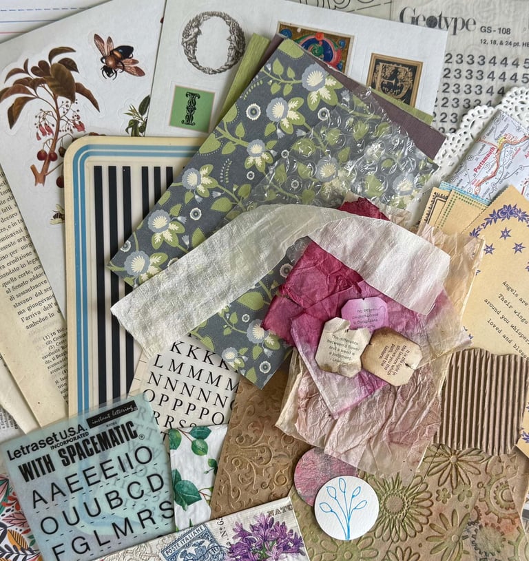 A collection of printed paper, book pages, ribbon, dyed tea bag, doily, transfer pieces
