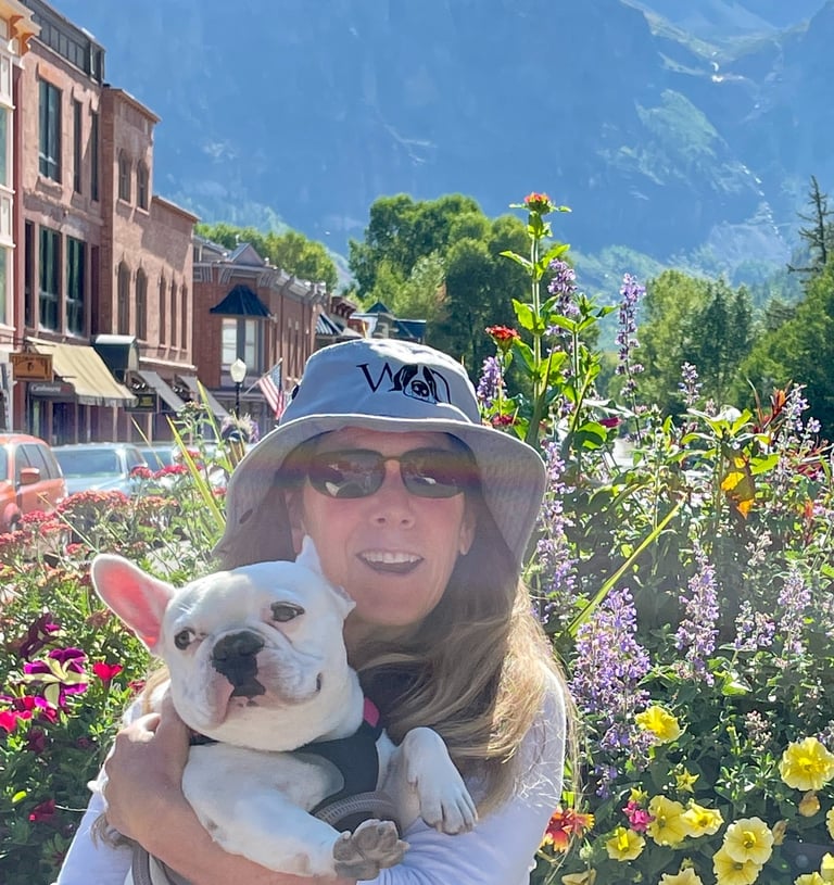a woman in a hat holding a dog